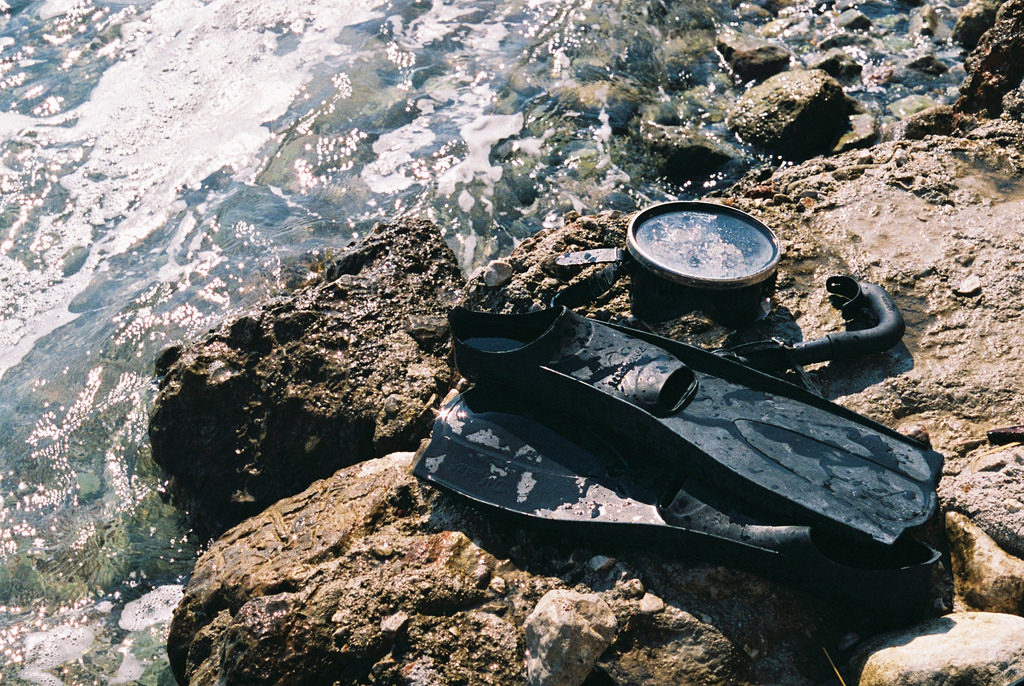 Flippers, mask and snorkel on rocks by sea